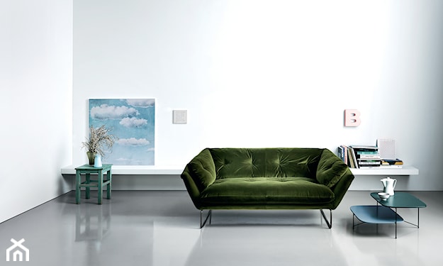 zielona sofa na drucianych nóżkach, białe ściany