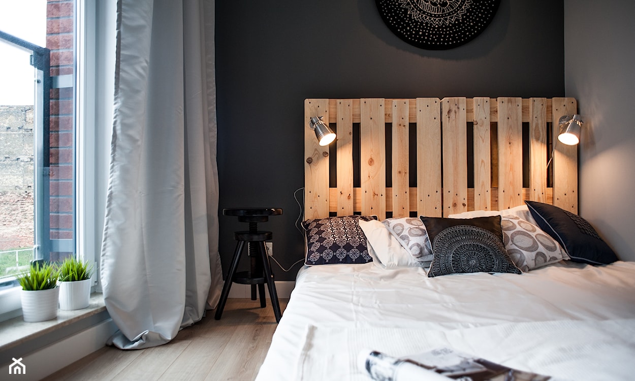 łóżko z palet, grafitowa ściana, srebrna zasłona, drewniana podłoga, biała pościel