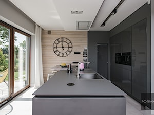 Szara kuchnia w domu pod Krakowem - Średnia otwarta z kamiennym blatem czarna szara z zabudowaną lodówką z lodówką wolnostojącą z nablatowym zlewozmywakiem kuchnia dwurzędowa z oknem, styl nowoczesny - zdjęcie od Studio FORMAT HOME