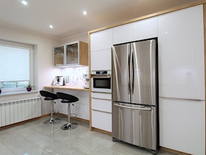 Białe kuchnie - Mała otwarta z salonem biała z zabudowaną lodówką kuchnia jednorzędowa z oknem z marmurem nad blatem kuchennym, styl nowoczesny - zdjęcie od WFM KUCHNIE