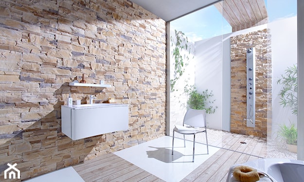 ściana z kamienia dekoracyjnego w łazience, podłoga z jasnego drewna, biała szafka ąłzienkowa