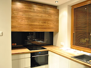 Kuchnia- lakier biały, czarny lacobel + drewno - Beżowa z zabudowaną lodówką z nablatowym zlewozmywakiem kuchnia w kształcie litery l z kompozytem na ścianie nad blatem kuchennym, styl nowoczesny - zdjęcie od Sysło-Projekt