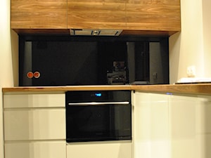 Kuchnia- lakier biały, czarny lacobel + drewno - Mała zamknięta biała czarna z zabudowaną lodówką kuchnia w kształcie litery l, styl nowoczesny - zdjęcie od Sysło-Projekt