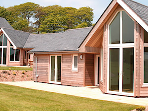 Osiedle domków w Cricket St. Thomas - Małe parterowe domy jednorodzinne drewniane z dwuspadowym dachem - zdjęcie od Sokółka Okna i Drzwi S.A.