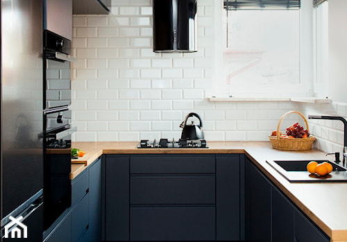 Kuchnia-grafit, biel i drewno - Mała zamknięta biała z zabudowaną lodówką z nablatowym zlewozmywakiem kuchnia z granatowymi frontami w kształcie litery u z oknem, styl nowoczesny - zdjęcie od Renee's Interior Design