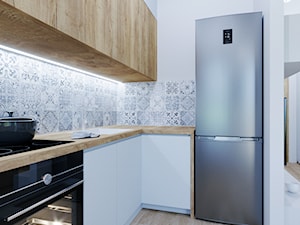 Kawalerka w błękicie - Mała otwarta biała szara z zabudowaną lodówką z nablatowym zlewozmywakiem kuchnia w kształcie litery l, styl nowoczesny - zdjęcie od Renee's Interior Design