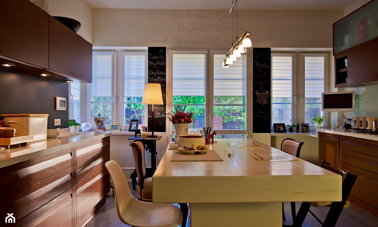 drewniane meble kuchenne, biały blat kuchenny, farba tablicowa na ścianie w kuchni, lampa podłogowa z białym abażurem