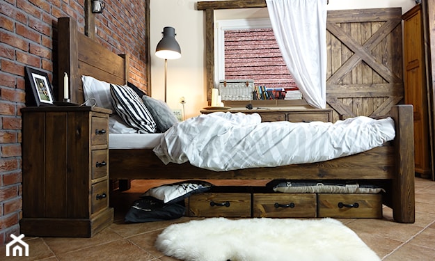 biały puchaty dywanik i drewniane łóżko z szufladami