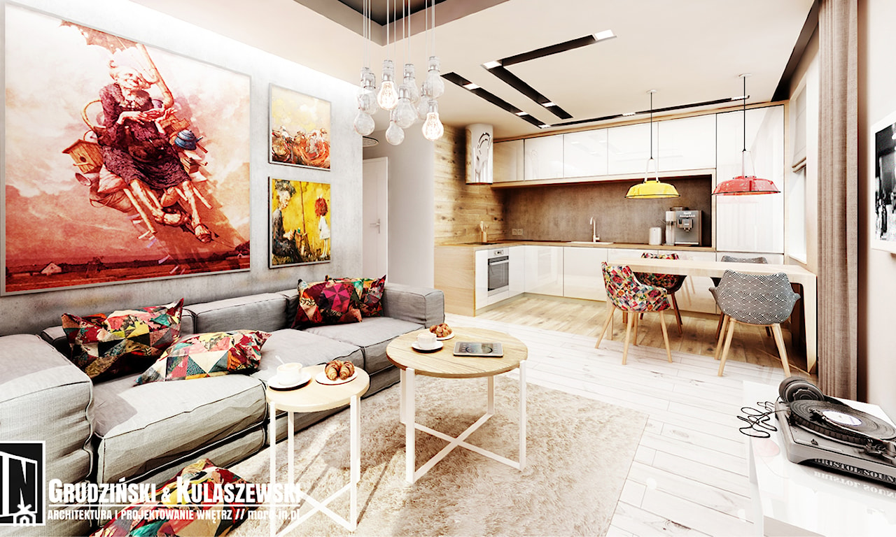 salon połączony z kuchnią, drewniana podłoga, białe meble, kolorowa grafika na ścianie, szara sofa, okrągły stolik z metalowymi nogami