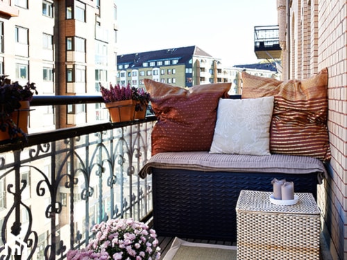 plecione meble na balkonie, metalowa balustrada, czerwona poduszka
