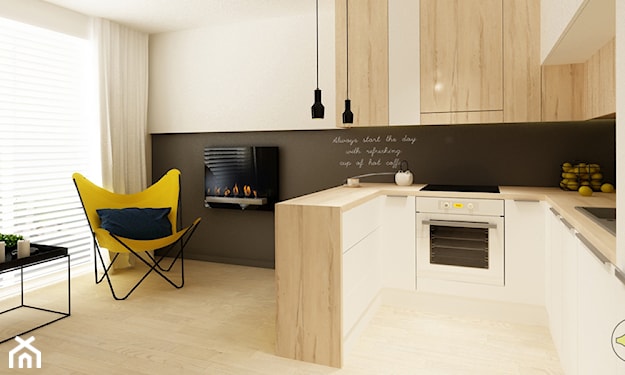 żółty fotel, czarna lampa wisząca, farba tablicowa, białe meble kuchenne z drewnianym blatem