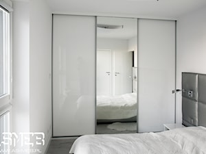 Reakizacja na Ochocie - Średnia biała z panelami tapicerowanymi sypialnia, styl minimalistyczny - zdjęcie od AS-MEB producent kuchni i mebli