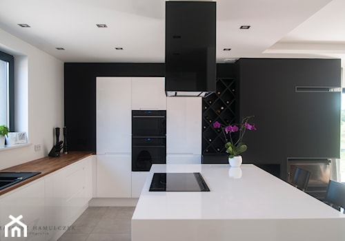 dom 220m2 - Duża otwarta biała czarna z zabudowaną lodówką z nablatowym zlewozmywakiem kuchnia w kształcie litery u z wyspą lub półwyspem, styl nowoczesny - zdjęcie od Pracownia Wielkie Rzeczy