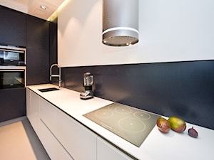 Kuchnia - Średnia otwarta biała czarna z zabudowaną lodówką z podblatowym zlewozmywakiem kuchnia jednorzędowa, styl minimalistyczny - zdjęcie od Fawre s.c.