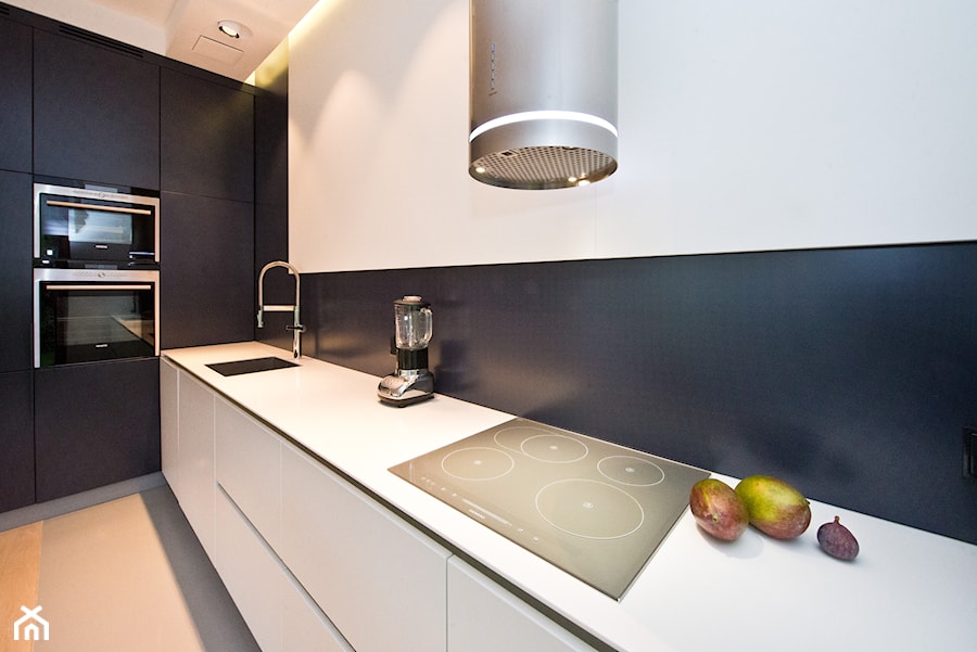 Kuchnia - Średnia otwarta biała czarna z zabudowaną lodówką z podblatowym zlewozmywakiem kuchnia jednorzędowa, styl minimalistyczny - zdjęcie od Fawre s.c.