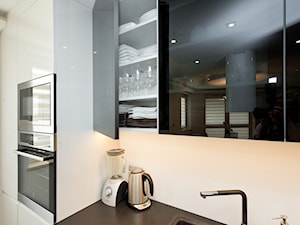 Kuchnia - Otwarta biała z zabudowaną lodówką z podblatowym zlewozmywakiem kuchnia jednorzędowa, styl nowoczesny - zdjęcie od Fawre s.c.