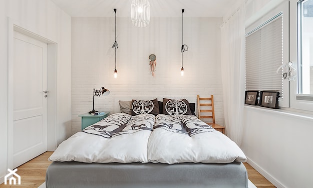 drewniana podłoga, szare łóżko, białe ściany, lampy żarówki