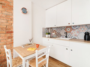 Apartament Andaluzyjski - Mała otwarta z salonem biała z zabudowaną lodówką z nablatowym zlewozmywakiem kuchnia jednorzędowa, styl rustykalny - zdjęcie od PracowniaPolka
