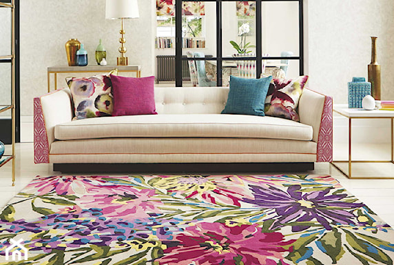 dywan z kwiaty, beżowa sofa, różowa poduszka, złota lampa