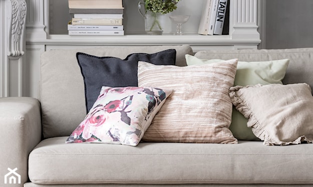 beżowa sofa, poduszki w kwiaty, ozdobne kolumny