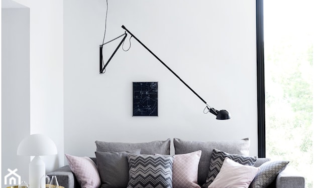 szara sofa, różowa poduszka, biała ściana, złoty stolik kawowy