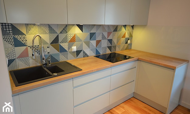 szkło między szafkami w niebieskie trójkąty, drewniana podłoga w kuchni