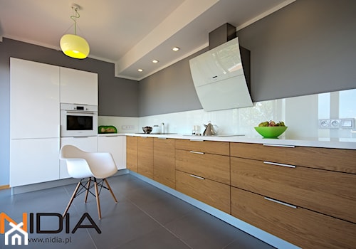 Apartament w Opolu (2011r) - Duża otwarta szara z zabudowaną lodówką kuchnia w kształcie litery l, styl minimalistyczny - zdjęcie od NIDIA