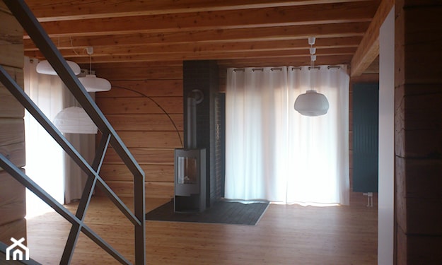 salon w domu z bali, piecyk, lampa wisząca z białym abażurem