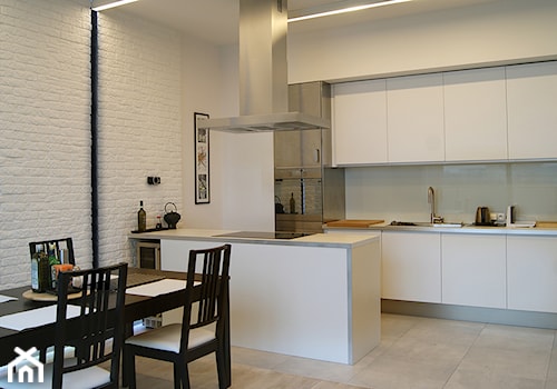 Średnia otwarta z salonem biała z zabudowaną lodówką z nablatowym zlewozmywakiem kuchnia dwurzędowa z kompozytem na ścianie nad blatem kuchennym, styl minimalistyczny - zdjęcie od Pracownia InSide