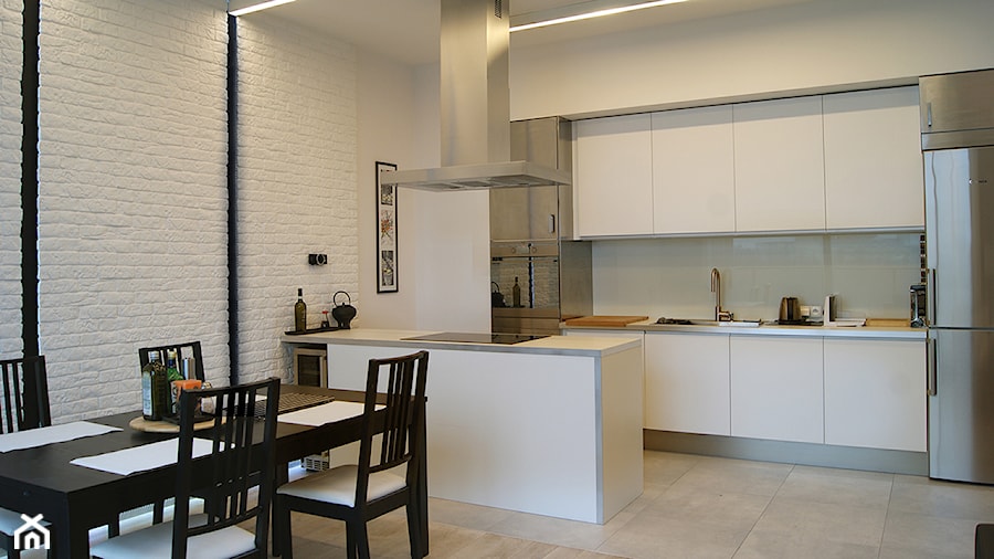 Średnia otwarta z salonem biała z zabudowaną lodówką z nablatowym zlewozmywakiem kuchnia dwurzędowa z kompozytem na ścianie nad blatem kuchennym, styl minimalistyczny - zdjęcie od Pracownia InSide