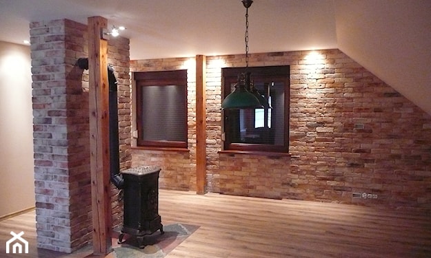ceglana ściana, drewniana podłoga, metalowy piec, metalowa lampa