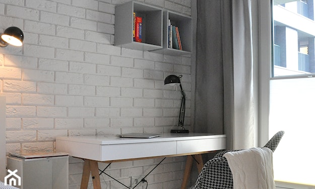 ceglana ściana i białe biurko