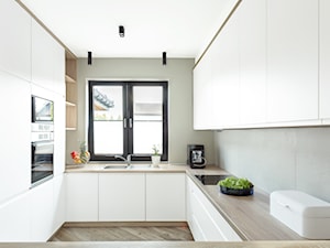 Dom jednorodzinny - Średnia otwarta biała z zabudowaną lodówką z podblatowym zlewozmywakiem kuchnia w kształcie litery u z oknem, styl nowoczesny - zdjęcie od Maciejewska Design