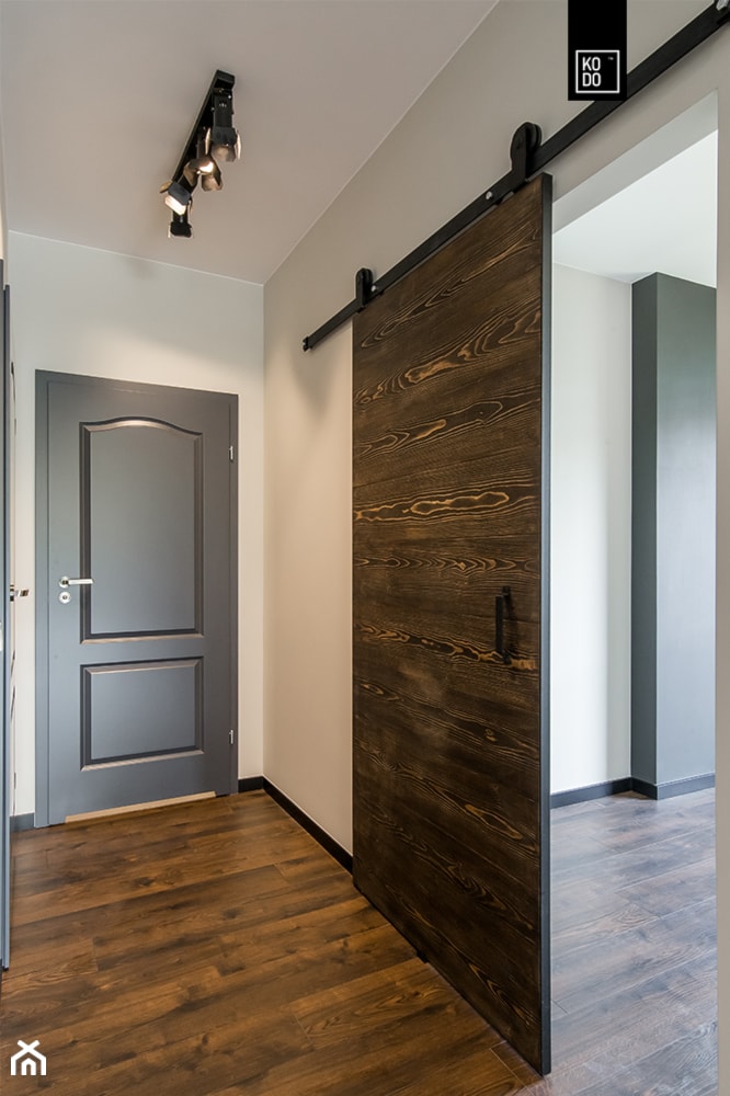 LIROWA - STYL LOFT - Średni biały brązowy szary z farbą na ścianie z drewnianymi drzwiami z gładkimi drzwiami z frezowanymi drzwiami z przesuwnymi drzwiami hol / przedpokój, styl industrialny - zdjęcie od KODO projekty i realizacje wnętrz - Homebook