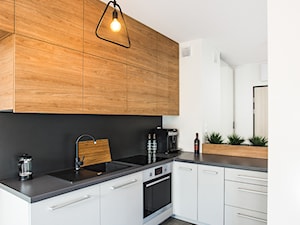 mieszkanie wrocław - Średnia otwarta z kamiennym blatem biała czarna z zabudowaną lodówką z lodówką wolnostojącą z nablatowym zlewozmywakiem kuchnia w kształcie litery l - zdjęcie od ESSA Architektura