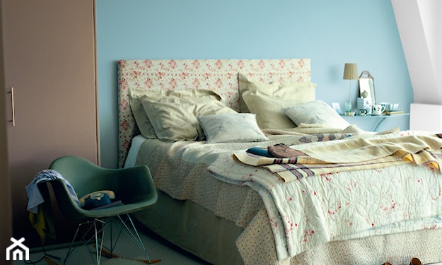 błękitna ściana, beżowa pościel, biały dywanik z długim włosiem