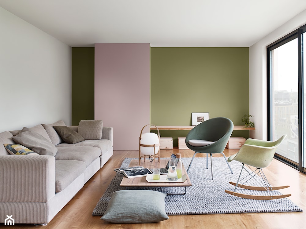 zielona ściana, różowa ściana, szara sofa, zielony fotel bujany, drewniane skrzynie