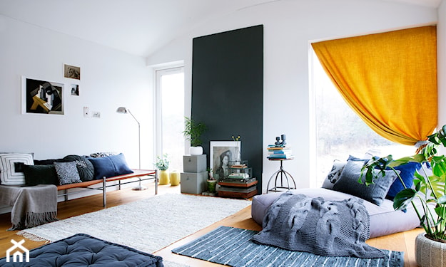 żółta zasłona, niebieski dywanik, beżowy dywanik, białe ściany, szara sofa