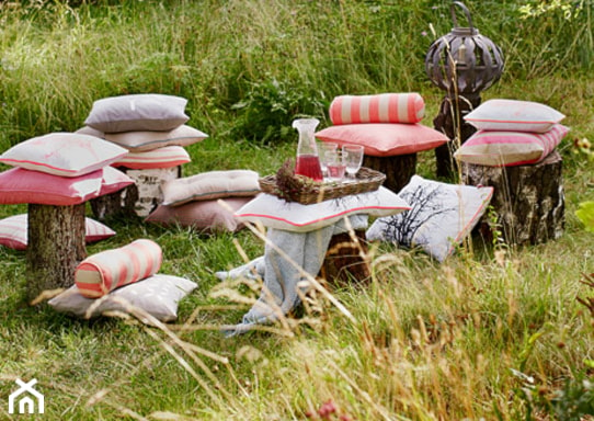 <h2 id="garden-party-w-formie-pikniku">Garden party w formie pikniku</h2>
<p>Jedni uwielbiają biesiadować przy stole, inni kochają leniuchować na <strong>leżakach, hamakach i pufach.</strong> Organizując garden party, zastanów się zatem, jaki wariant woleliby Twoi goście. Jeżeli lubią luźną, leniwą atmosferę, możesz z powodzeniem zrezygnować z klasycznego kompletu jadalnianego i postawić na miękkie tekstylia. W rolach głównych powinny wówczas występować <strong>poduchy, narzuty i koce</strong> – rozłożone na trawie zawsze tworzą wygodny, piknikowy zakątek. Jako stoliki natomiast, możesz wykorzystać <strong>pieńki drzew, drewniane ławki i taborety.</strong> Świetnie sprawdzą się także <strong>skrzynki po owocach oraz dekoracyjne tace z uchwytami.</strong></p>
