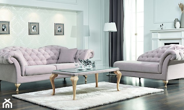 różowa sofa, kremowy dywan, stolik na złotych nóżkach ozdobnych