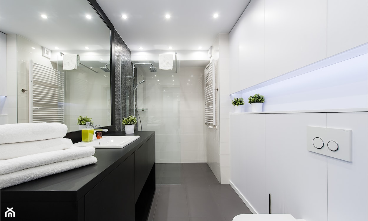 kabina prysznicowa walk-in, białe płytki łazienkowe, czarne szafki łazienkowe