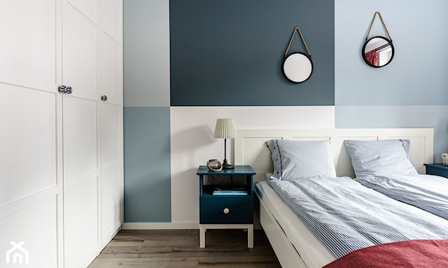 biała szafa w sypialni, kwadraty w odcieniach niebieskiego na ścianie, pościel w paski, drewniana podłoga