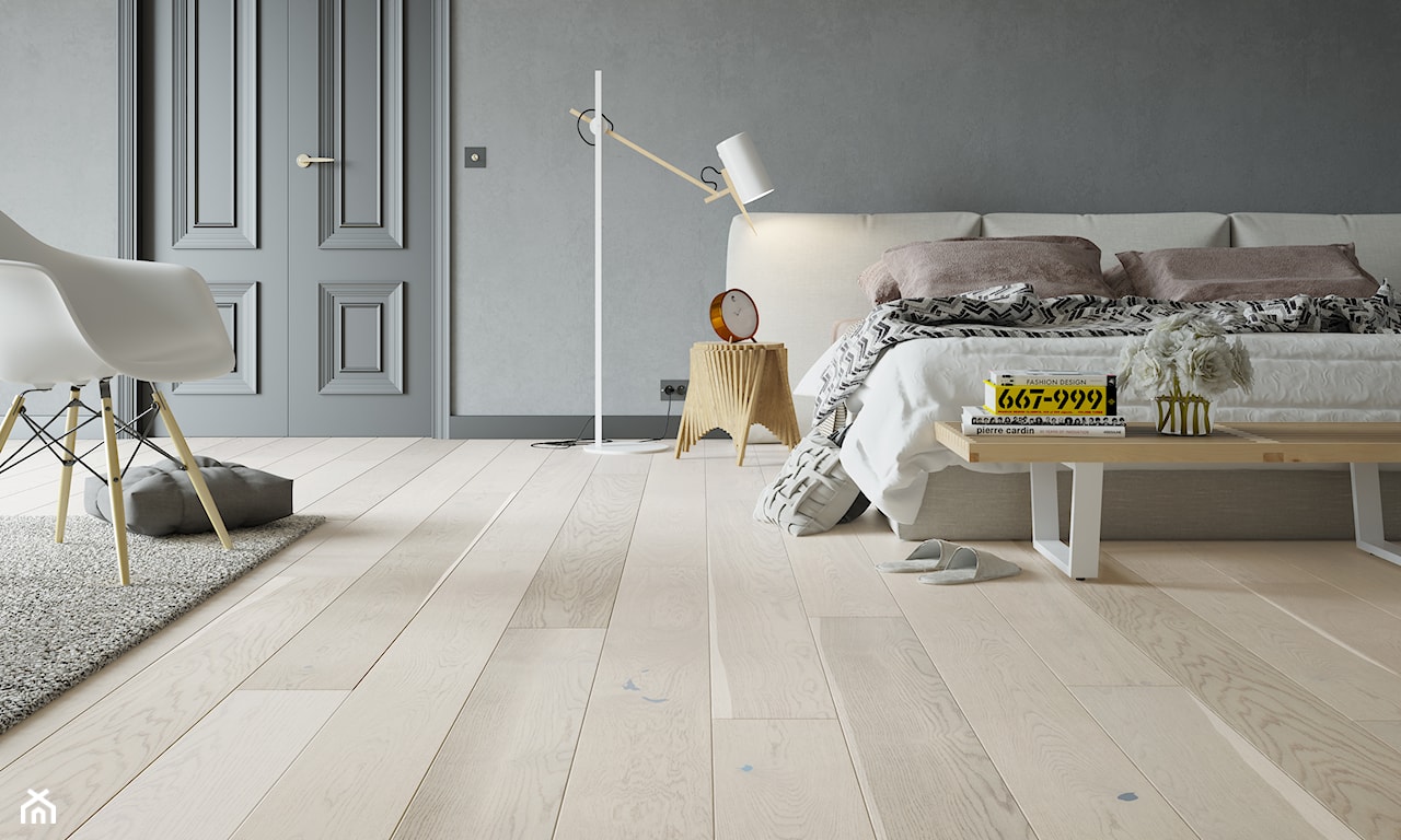 drewniana podłoga Barlinek, biały fotel, szary dywan z długim włosiem, kremowe łóżko
