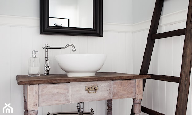 drewniana drabina w łazience, różowa szafka pod umywalką, lustro z czarną ramą