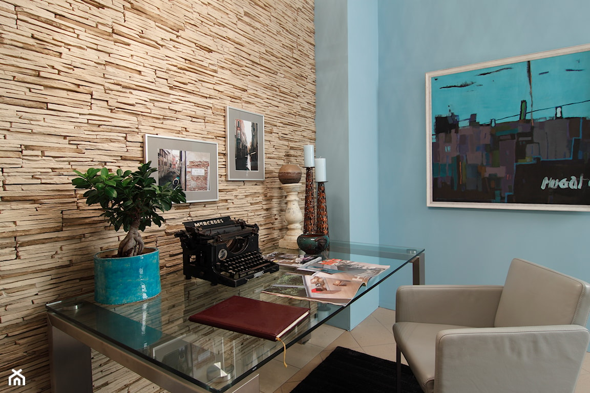 beżowy kamień dekoracyjny, niebieska ściana, biurko ze szklanym blatem, beżowy fotel