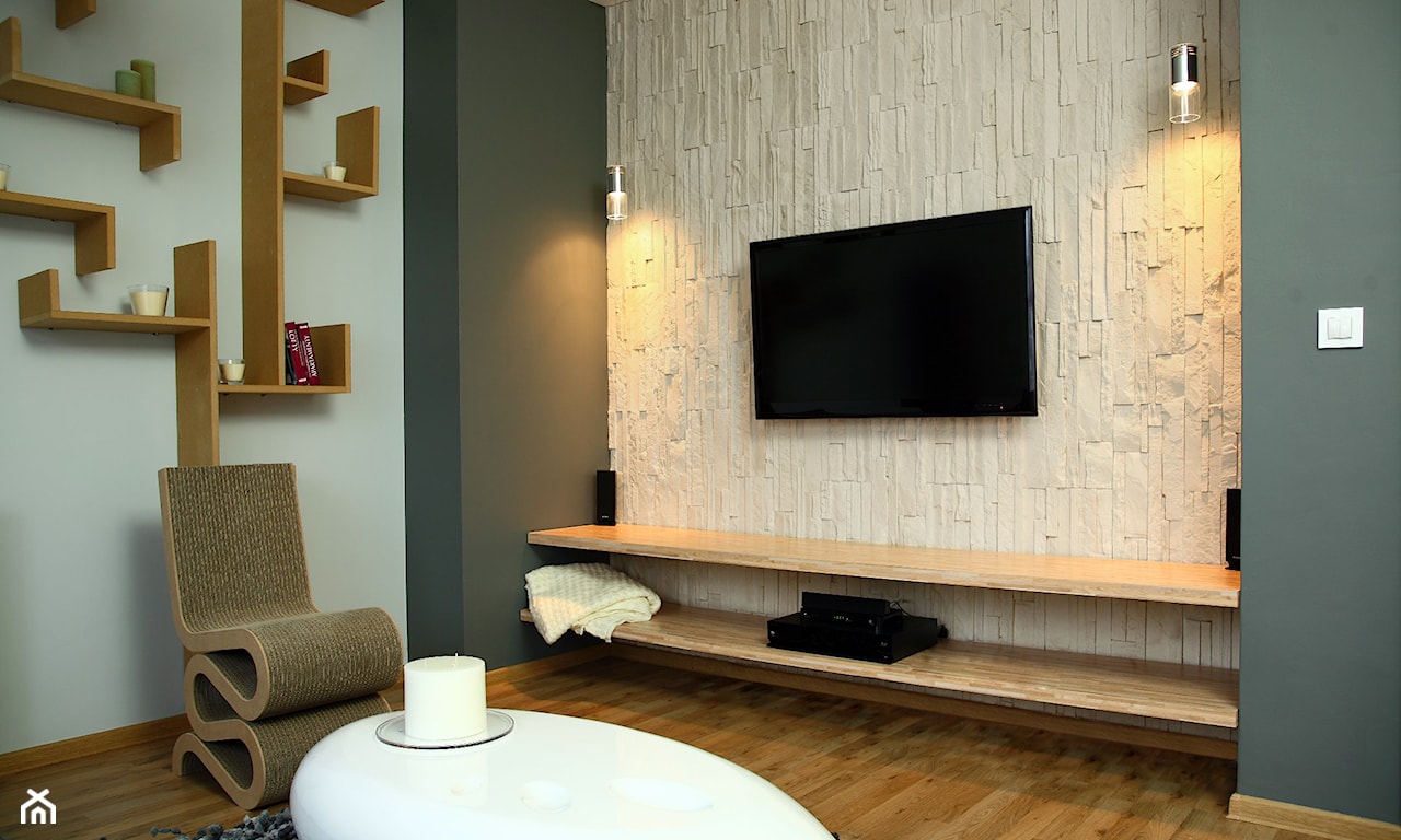 beżowy kamień dekoracyjny na ścianie w salonie, drewniana podłoga, biały owalny stolik