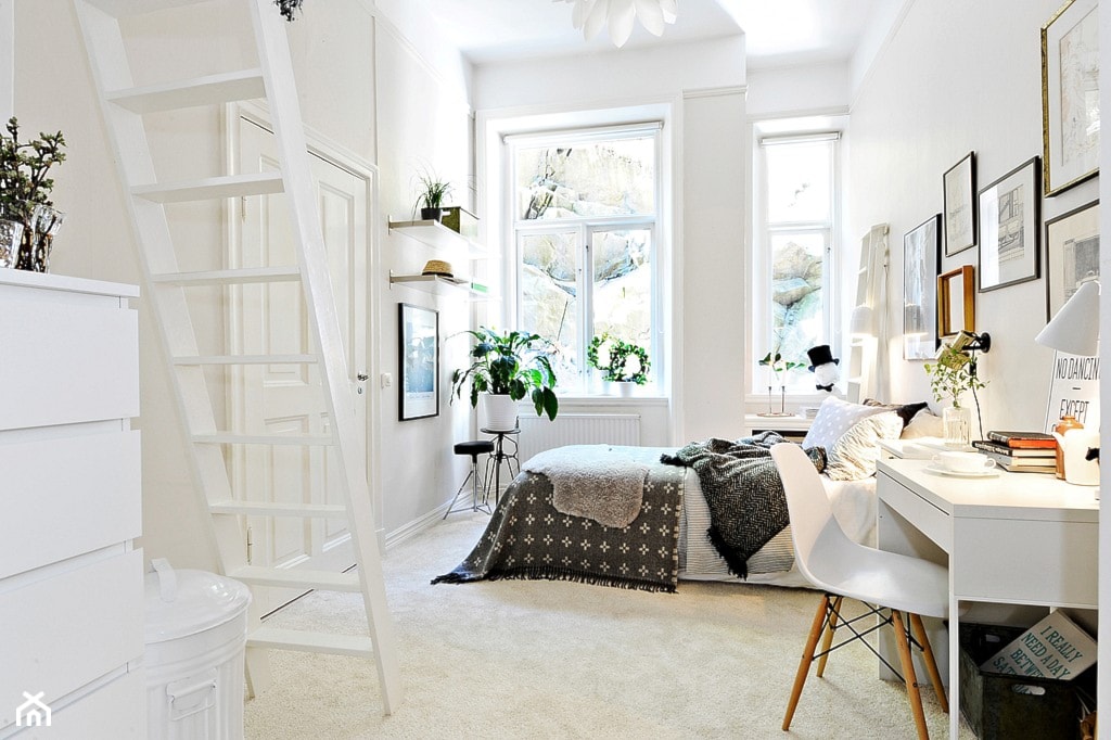 biały pokój z dywanem i schodami na poddasze