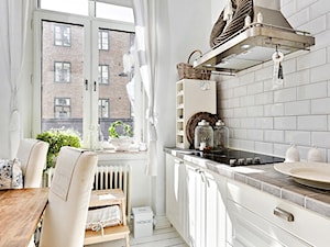 Mieszkanie pełne bieli - Mała zamknięta z salonem z kamiennym blatem biała kuchnia w kształcie litery u z oknem, styl skandynawski - zdjęcie od Casa Bianca
