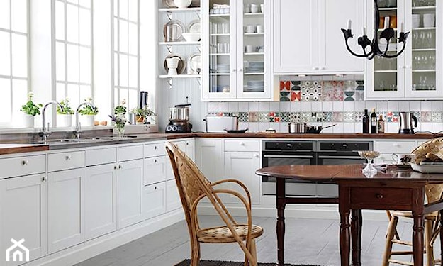 kuchnia w stylu skandynawskim, białe meble, wiklinowe krzesło, drewniany stół, metalowy żyrandol