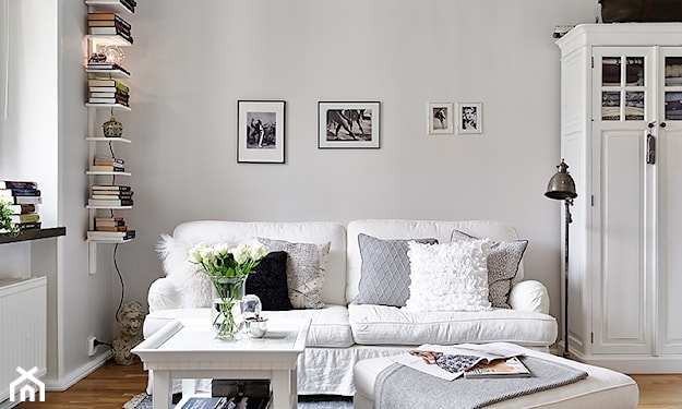 biała sofa, metalowa lampa stojąca, szary dywan